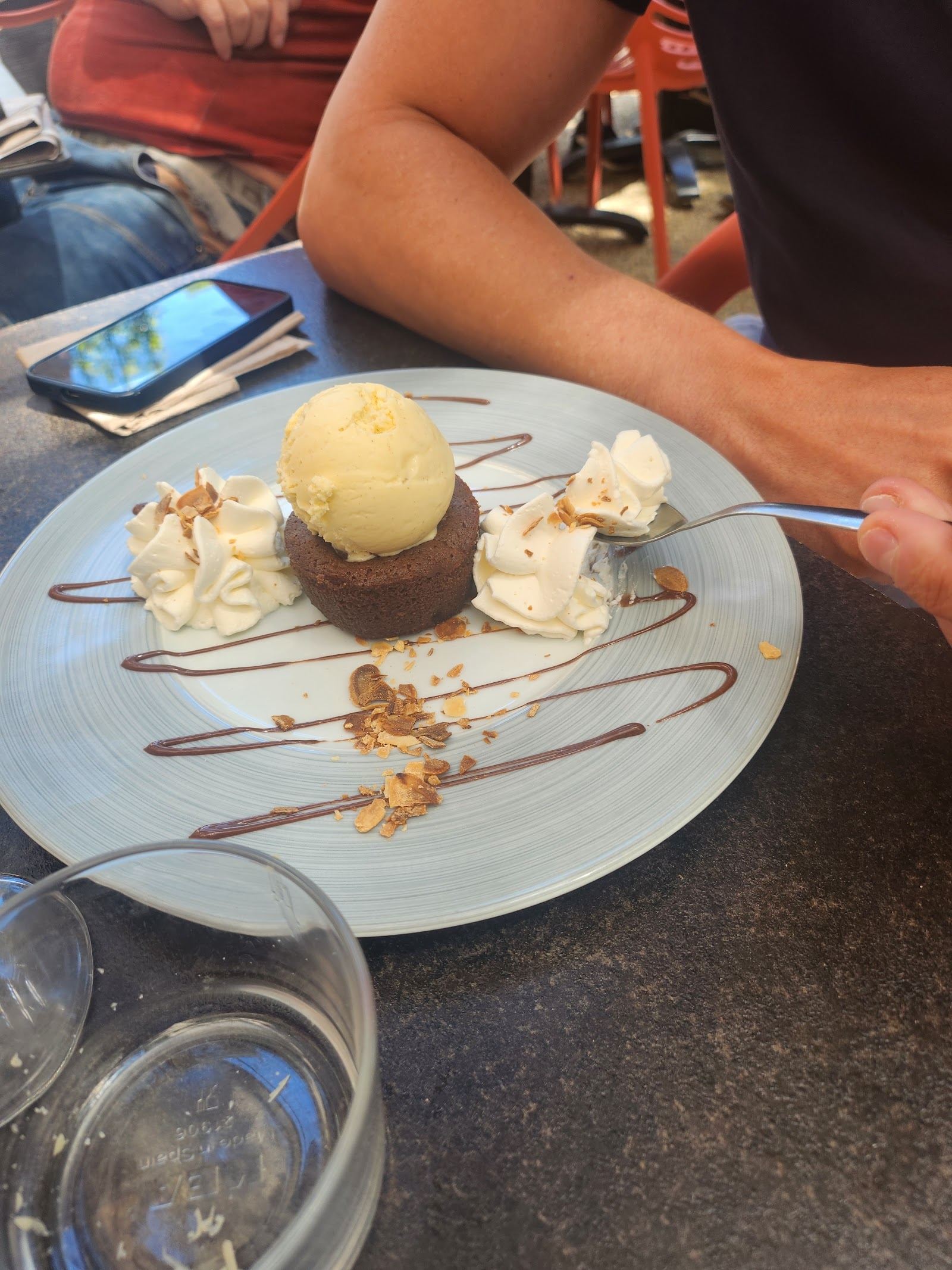 Dessert au chocolat avec une boule de glace, sauce et chantilly