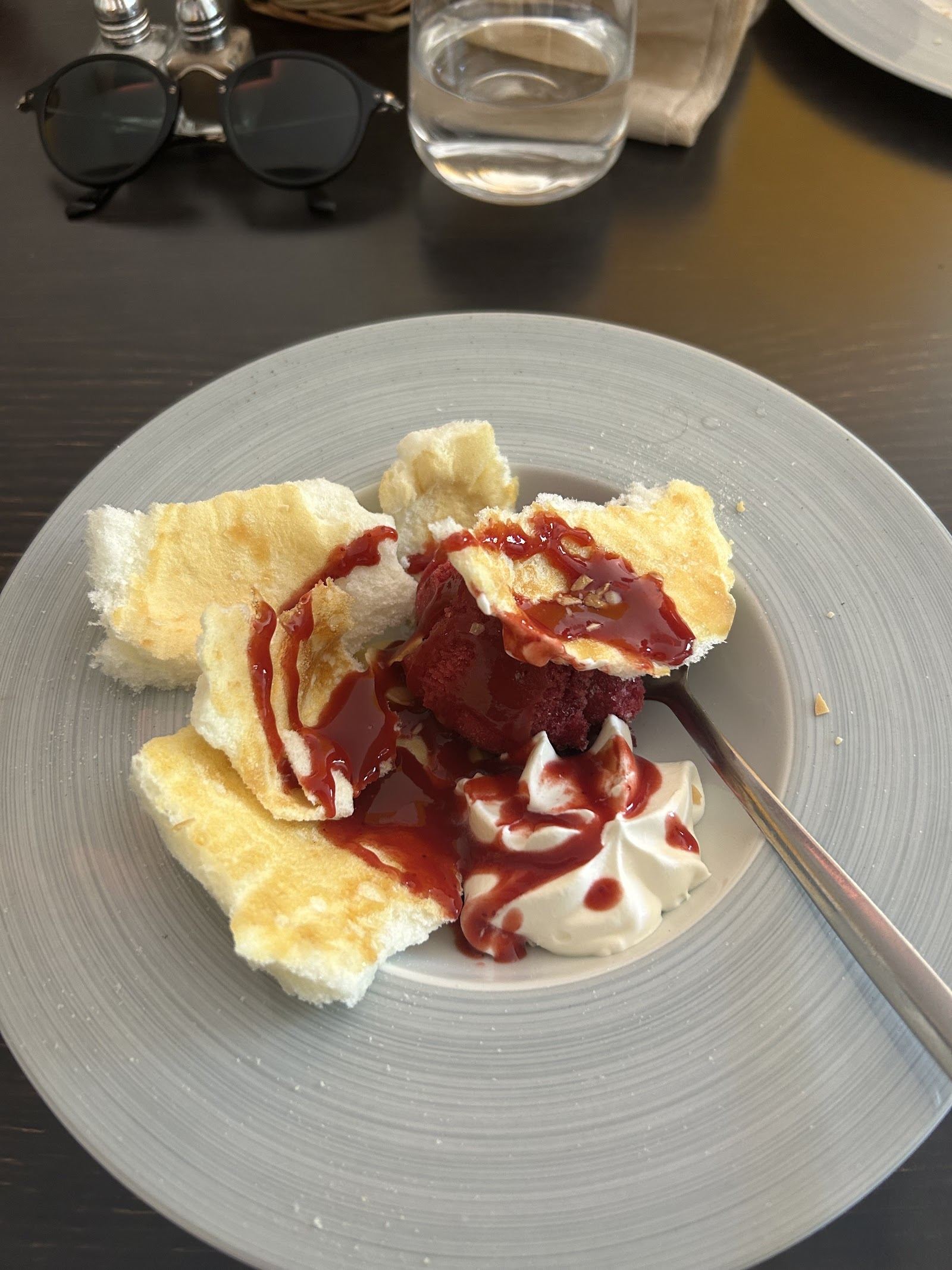 Dessert maison dressé sur une assiette grise, coulis rouge