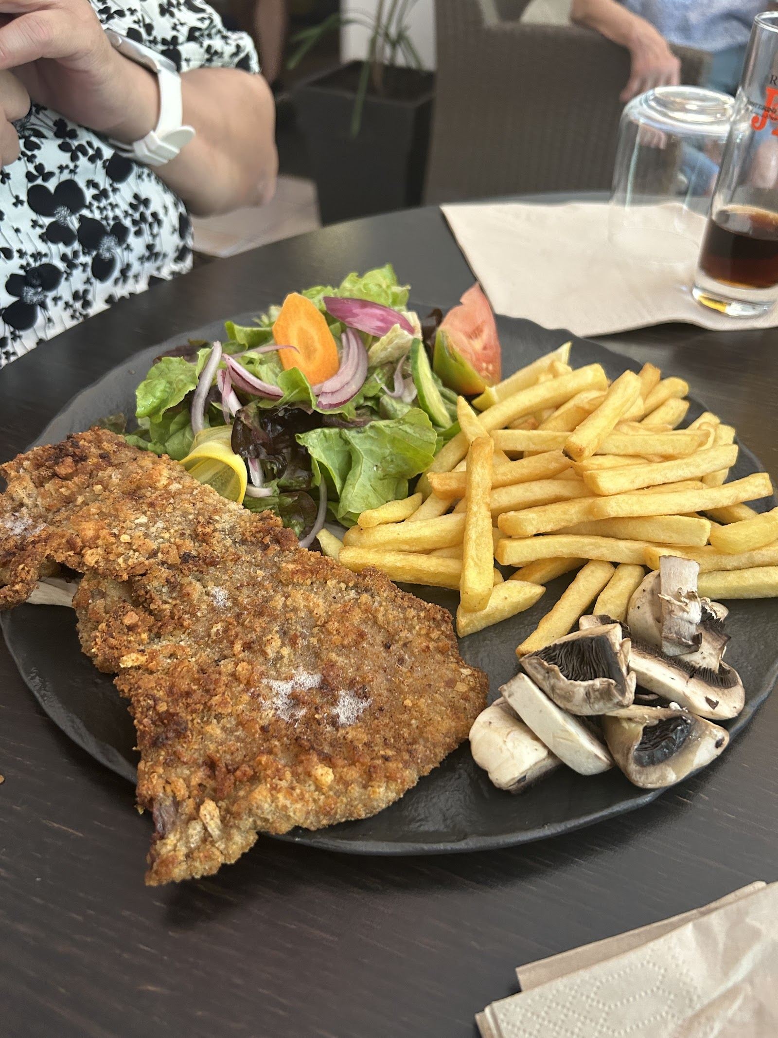 Escalope panée accompagnée de frites, salade et champignons